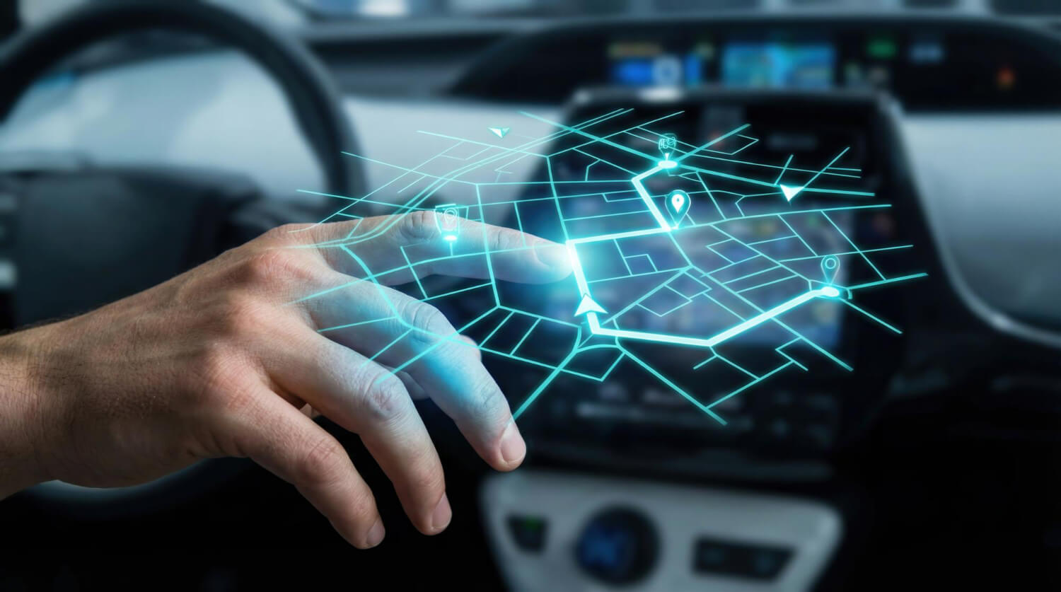 Hand above a car dashboard with a digital map hologram